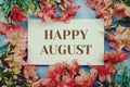 Happy August text with flower frame on blue background