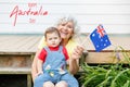 Happy Australia Day card with greeting text. Happy old woman grandmother with grandson baby boy waving Australian flag. Family