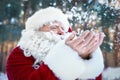 Happy Authentic Santa Claus blowing snow from his hands Royalty Free Stock Photo