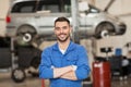 Happy auto mechanic man or smith at car workshop Royalty Free Stock Photo