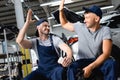 Happy auto mechanic sitting and giving