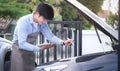 Happy auto repairman writing notes while checklist for repair machine a car in auto repair shop