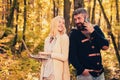 Happy autumn couple. Business couple - woman browsing Internet on a notebook, man using mobile phone outdoors. Autumn Royalty Free Stock Photo