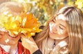 Happy autumn (fall) couple. Young woman and man having fun, enjoying in sunny autumnal day. Yellow leaves Royalty Free Stock Photo