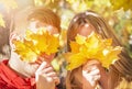 Happy autumn (fall) couple. Young woman and man having fun, enjoying in sunny autumnal day. Yellow leaves Royalty Free Stock Photo