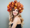 Happy autumn woman in fall leaves crown on gray background