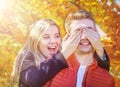 Happy autumnal fall couple. Young woman and man having fun, enjoying outdoors. Yellow leaves background. Royalty Free Stock Photo