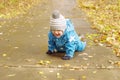 Happy baby age of 1 year creeps on path in park outdoors Royalty Free Stock Photo