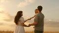 Happy baby in arms of father and mother. little daughter, dad and mom play in wheat field. baby travels across field Royalty Free Stock Photo