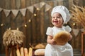 Happy baby baker holding bread and smiling