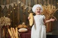 Happy baby baker holding bread and smiling