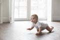 Happy baby in bodysuit crawling on knees Royalty Free Stock Photo