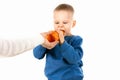Happy baby boy eating carrot, isolated Royalty Free Stock Photo