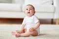 Happy baby boy or girl sitting on floor at home Royalty Free Stock Photo