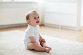 Happy baby boy or girl sitting on floor at home Royalty Free Stock Photo