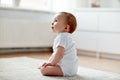 Happy baby boy or girl sitting on floor at home Royalty Free Stock Photo