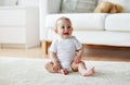 Happy baby boy or girl sitting on floor at home Royalty Free Stock Photo