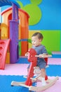 Happy baby boy playing horse on playground, wooden rocking Royalty Free Stock Photo