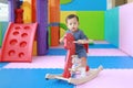 Happy baby boy playing horse on playground, wooden rocking Royalty Free Stock Photo