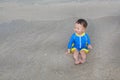 Happy baby boy in swimming suit has fun playing sea waves and water on the beach Royalty Free Stock Photo