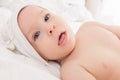 Happy baby boy wearing hooded towel lying on a bed after bath or shower. Royalty Free Stock Photo