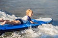 Happy baby boy - young surfer ride on surfboard with fun on sea waves. Active family lifestyle, kids outdoor water sport Royalty Free Stock Photo