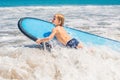 Happy baby boy - young surfer ride on surfboard with fun on sea