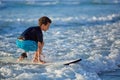 Skilled teenager riding surfboard and balancing a long wavy sea