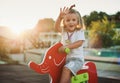 Happy baby child riding a red elephant at the playground Royalty Free Stock Photo