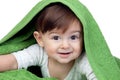 Happy baby covered with a green towel