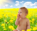 Happy baby-girl among dandelions in Spring