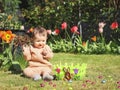 Happy baby girl with easter chocolate egg on the lawn. Royalty Free Stock Photo