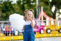 Happy baby girl eating cotton candy at amusement Park in summer Royalty Free Stock Photo