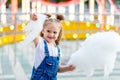 Happy baby girl eating cotton candy at amusement Park in summer Royalty Free Stock Photo