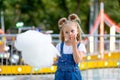 Happy baby girl eating cotton candy at amusement Park in summer Royalty Free Stock Photo