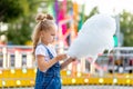 Happy baby girl eating cotton candy at amusement Park in summer Royalty Free Stock Photo
