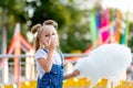 Happy baby girl eating cotton candy at amusement Park in summer Royalty Free Stock Photo