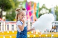 Happy baby girl eating cotton candy at amusement Park in summer Royalty Free Stock Photo