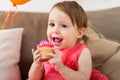 Happy baby girl eating cupcake on birthday party Royalty Free Stock Photo
