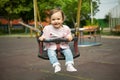 Happy baby girl is giving in swing Royalty Free Stock Photo