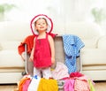 Happy baby girl is going on trip, pack suitcase Royalty Free Stock Photo