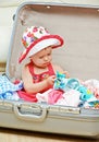 Happy baby girl is going on trip, pack suitcase Royalty Free Stock Photo