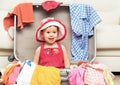 Happy baby girl is going on trip, pack suitcase Royalty Free Stock Photo