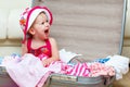 Happy baby girl is going on trip, pack suitcase Royalty Free Stock Photo