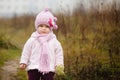 Happy baby girl in a pink hat and scarf laughs Royalty Free Stock Photo