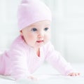 Happy baby girl in a pink knitted hat