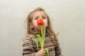 Happy baby girl rejoices and smiles with a bouquet of multi-colored tulips in hands Royalty Free Stock Photo