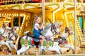 Happy baby girl rides a carousel on a horse in an amusement Park in summer Royalty Free Stock Photo