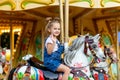 Happy baby girl rides a carousel on a horse in an amusement Park in summer Royalty Free Stock Photo