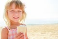 Happy baby girl on the sea in summer eating ice cream outdoors Royalty Free Stock Photo